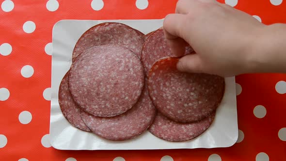 Person Taking Slices of Smoked Sausage