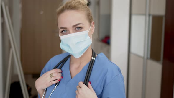 Portrait of Young Female Doctor in Medical Mask, Blue Coat and Stethoscope