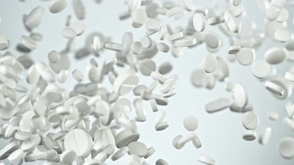Super Slow Motion Shot of Flying White Pills on Gradient Grey Background at 1000Fps