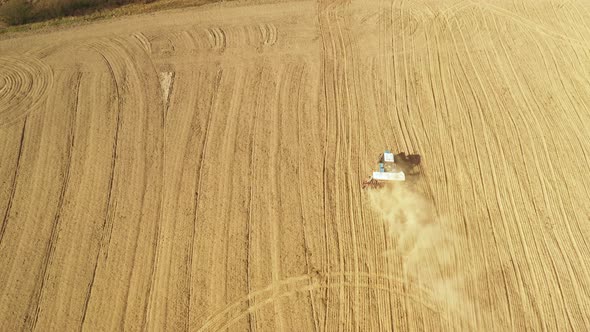 Aerial View Tractor With Seed Drill Machine Sowing Seeds For Crops In Spring Season