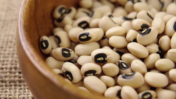 Traditional Castilla beans. Dry spanish legumes falling into a rustic wooden bowl