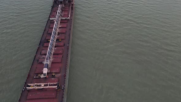 Long industrial cargo vessel shipping on Detroit river, aerial fly over view