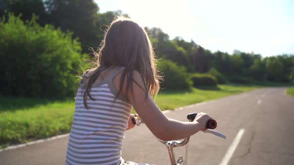 Back View Cute Little Girl Riding Bike On Driveway