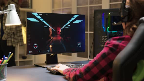 Woman with Headphones Sitting on Gaming Chair Playing Video Games on Computer