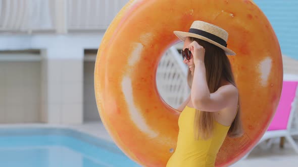 Carefree Beautiful Stylish Caucasian Blonde Woman with Long Hair in Hat and Sunglasses By Pool in