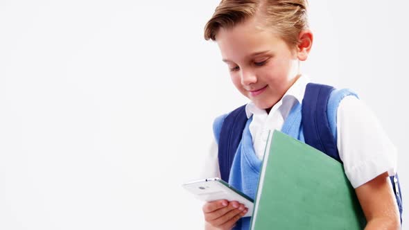 Schoolboy using mobile phone against white background