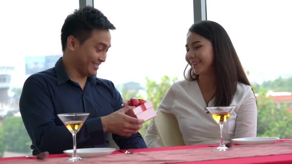 Romantic Couple Giving Gift to Lover at Restaurant