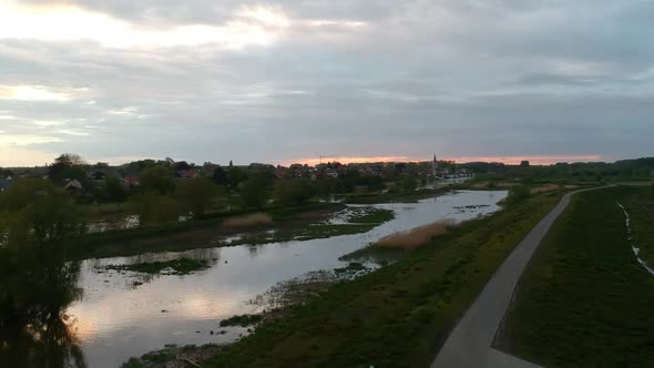 Aerial drone flyover swampland at dramatic cloudy sunset, dolly side