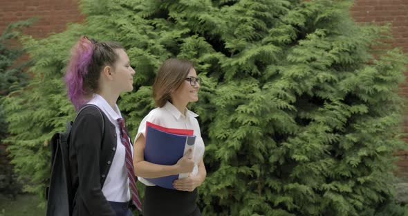 Woman Teacher and Girl Teenager High School Student Walking