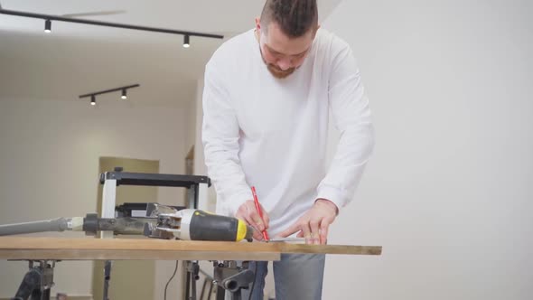 Carpenter Makes Measurements and Draws on Wood
