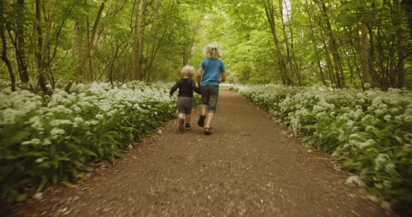 Brothers Enjoying and Running in the Middle of the Forest Woods