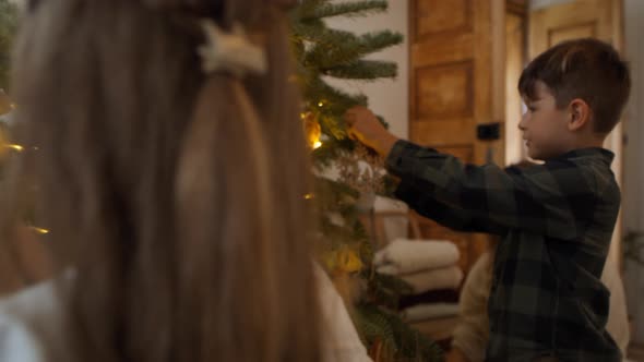 Family decorating the Christmas tree. Shot with RED helium camera in 8K