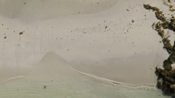 Top down view of beach and calm waves breaking in the sand