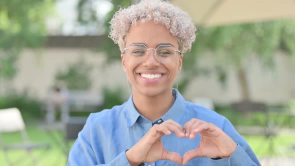 Portrait of Young African Woman Making Heart Shape with Hands