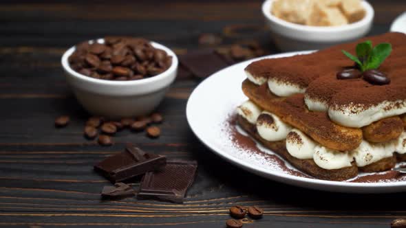 Portion of Classic Tiramisu Dessert, Cup of Coffee and Milk or Cream on Wooden Background