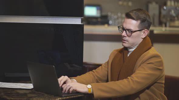 Entrepreneur Sit Thinking About Business Deals and Plans Using Laptop in Hotel Lobby Hall