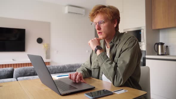 Successful Freelancer Ginger Man Holding Credit Card Using Laptop