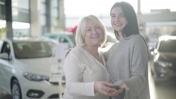 Portrait of Two Caucasian Women Holding Car Keys, Looking at Camera and Smiling