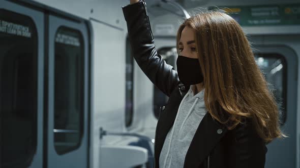 Young Woman Wearing Protective Medical Mask Commuting in Subway in Empty Carriage