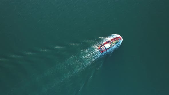 Drone flying over a fishing boat that is sailing on the sea