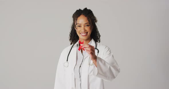 Video of smiling biracial female doctor holding orange kidney cancer ribbon