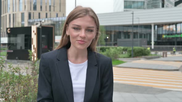 Excited Young Businesswoman Talking on Online Video Call While Walking on the Street