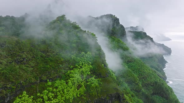 Flying Through Rain Clouds Above Green Mountain Tops with Rainforest Hawaii