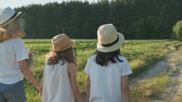 Children Three Girls in Hats Holding Hands Running Back Along Rural Country Road