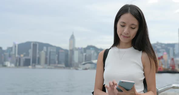 Woman using mobile phone to take photo in Hong Kong 