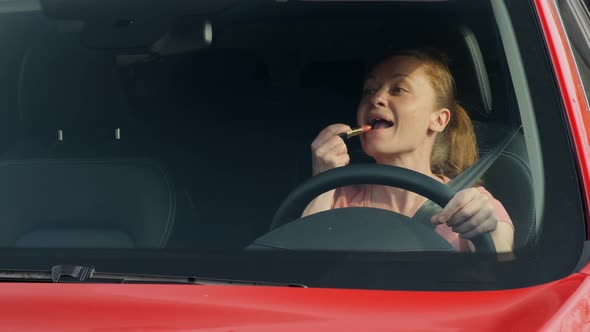 Woman Paints Her Lips with Lipstick While Driving