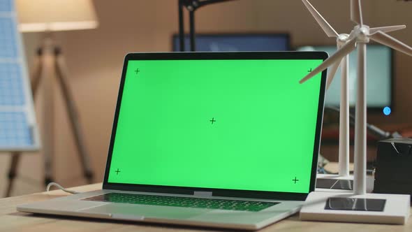 Close Up Of Green Screen Laptop And Wind Turbine On The Table Next To The Solar Cell At The Office