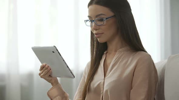 Young Woman Looking Into Camera with A Tablet Satisfied Person