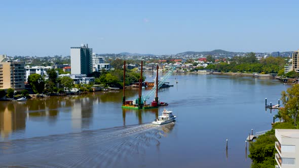 A floating crane barge is manoeuvred up the river to help repair the damage of the ferry terminals a