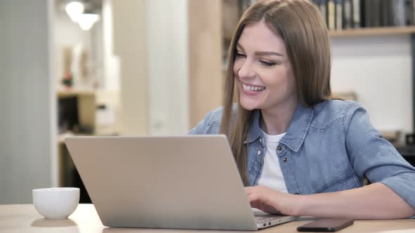 Creative Woman Celebrating Success While Working on Laptop