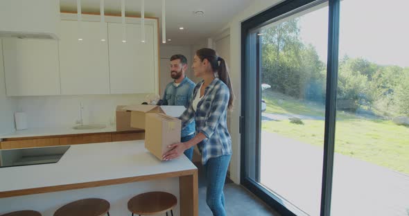 Couple Carrying Boxes Into New Home On Moving Day.