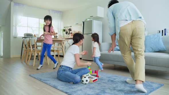 Asian happy family, father play catch running with young little girl kid around mother in house.