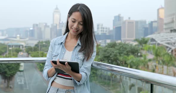 Woman using digital tablet computer in the city