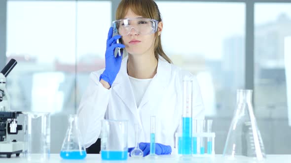 Female Scientist Talking on Phone in Laboratory