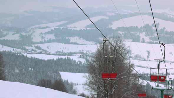 View of the Ski Lift Against the Background of a Mountain Forest and Gray Sky in the Carpathians