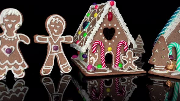 Creative Christmas holiday scene with gingerbread Houses and people on black background