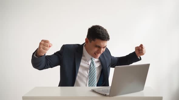 Happy Office Worker Works at Laptop and Funny Rejoices at Successful Deal