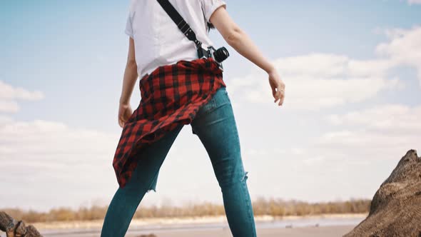 Happy Young Woman with Outstretched Hands Enjoying Sunny Day. Bright Blue Sky with Clouds in the