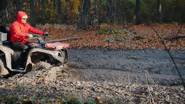 Outdoor Activity - a Man Riding a Red ATV in the Forest - Ride in the Mud