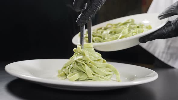 Cooking Pasta in Italian Restaurant. Chef Serving Cooked Pasta on Plate. Slow Motion. Vapour or