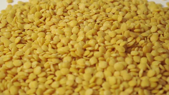 Peeled yellow lentils close-up fall in a pile