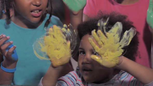 Cute Girls Having Fun with Paints on Window Glass