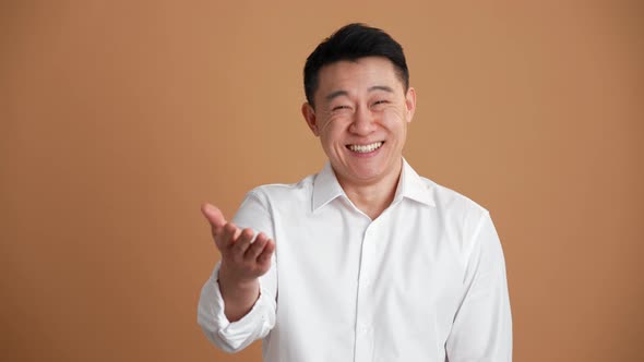 Smiling Asian man wearing white shirt laughing at the camera