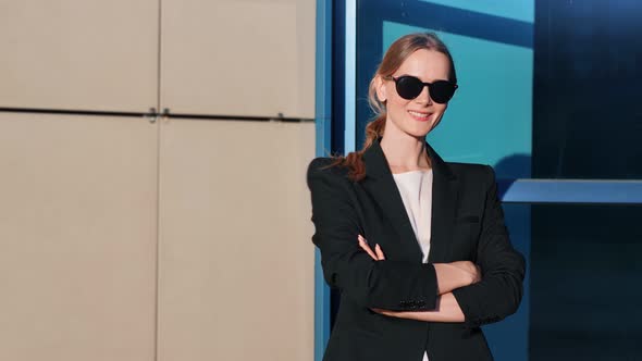 Trendy Businesswoman in Black Jacket Posing at Modern Building