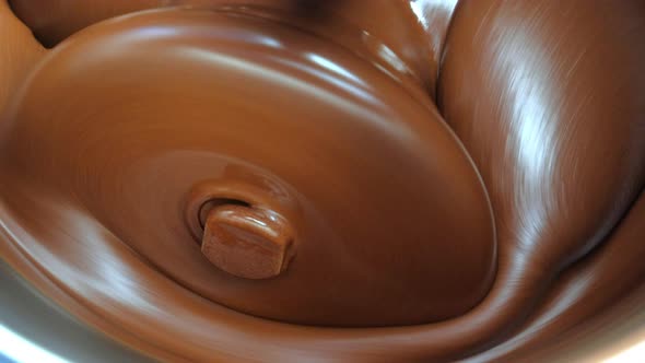 Closed-up shot of Chocolate grinding in a grinder machine
