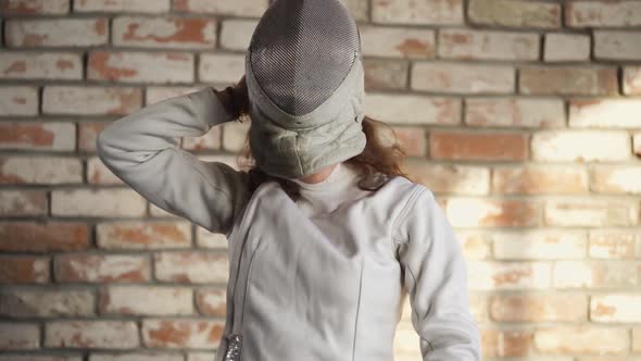 Young and Beautiful Woman Wearing a Helmet for a Head on a Head for Fencing